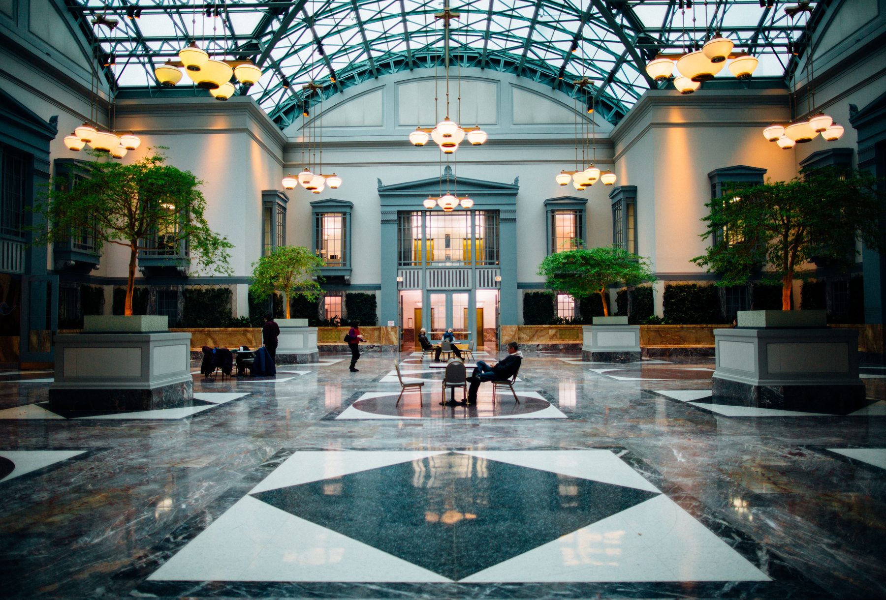 A grand, light-filled atrium with a glass ceiling and calm seating — the feeling of wellness in a beautiful destination.