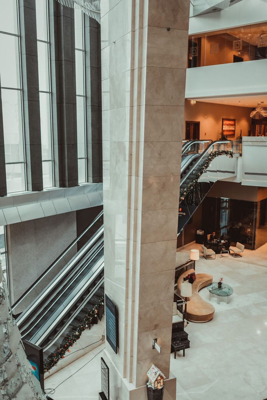 A multi-level hotel interior with escalators and marble columns, showing the scale of a hospitality property.