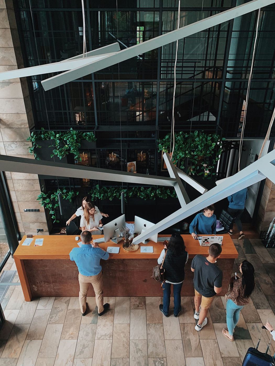 A hotel reception desk with staff assisting guests — the existing offering a property already has.