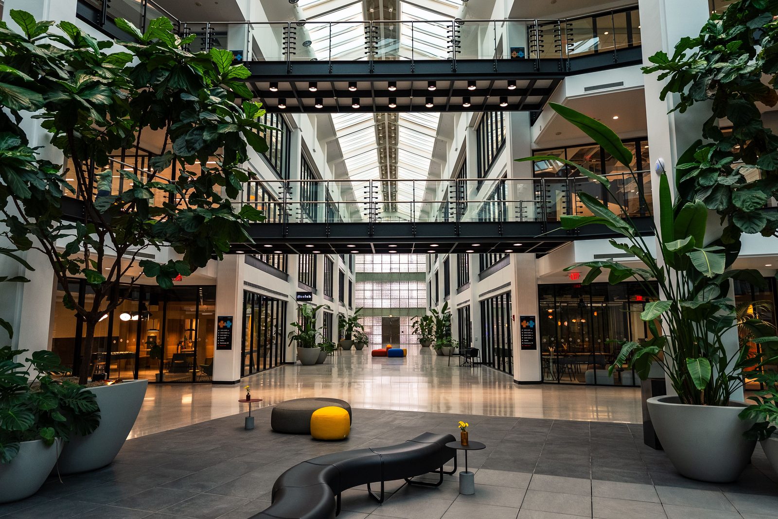 A modern multi-floor hotel atrium with a skybridge.